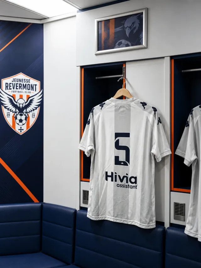 Maillot domicile du JRFC suspendu dans le vestiaire, à côté du blason du club